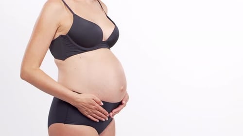 Young Happy and Healthy Pregnant Woman in Front of White Background Studio Video Baby Expectation