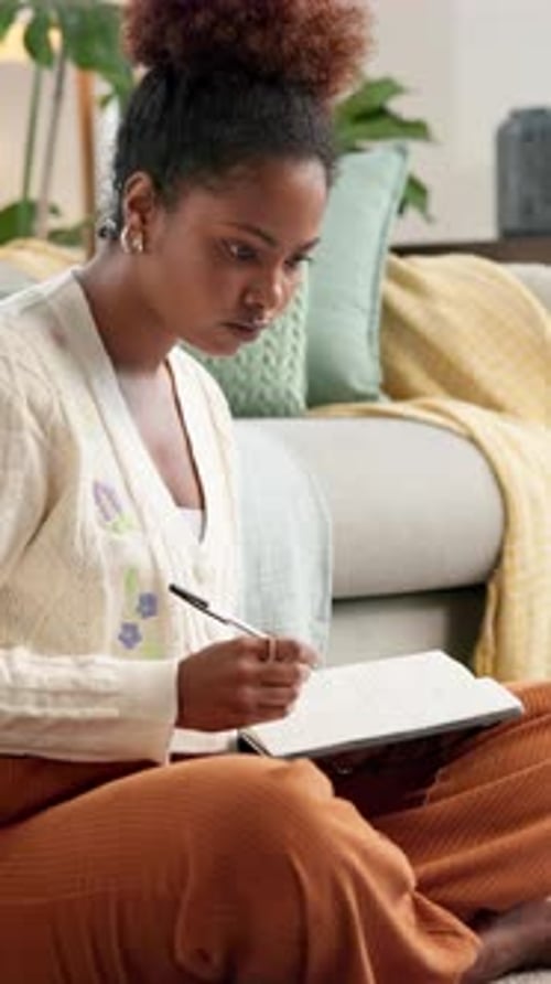 Woman, student and writing notes at house for studying, research and reminder of assessment