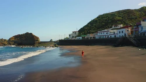 Woman Running in the Morning on Black Volcanic Sand Beach
