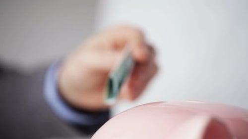 Businessman securing financial future inserting euro savings into piggy bank