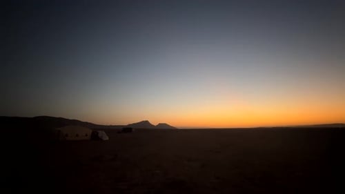 Camp and tent in middle of Sahara Desert sand at beautiful sunrise