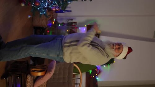 Senior Man Dancing by Christmas Tree at Home