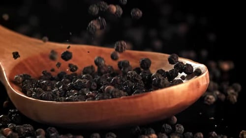 Black Pepper Falls on a Wooden Spoon Filmed on a Highspeed Camera at 1000 Fps