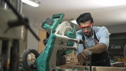 Carpenter is working together at workshop.