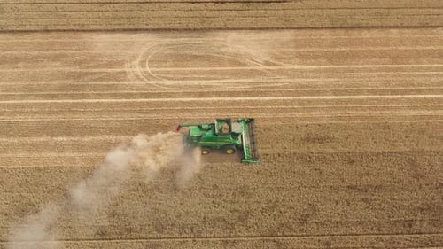 Aerial view of a combine harvester working in a field at summer