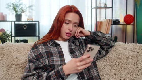 Woman Relaxing Indoors Browsing on Mobile Phone