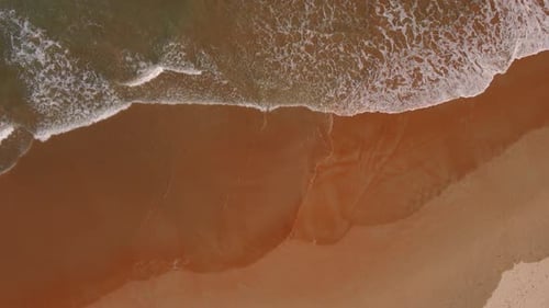 Vista aérea de las olas del mar bañan la playa de arena