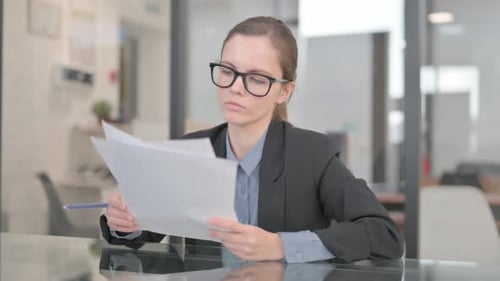 Business Woman Reviews Documents in Office