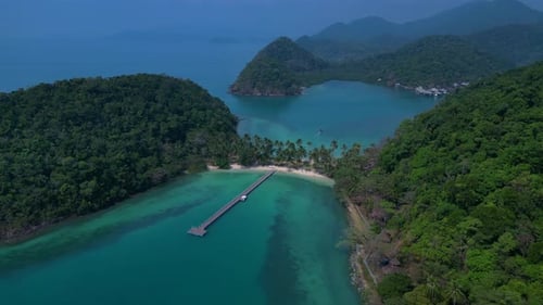 Island with pier leading to tropical beach. Fabulous aerial view flight drone