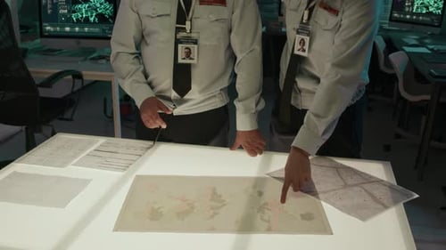 Military Personnel Study Maps in Dark Operations Room