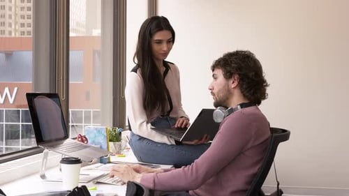 Jeunes gens d'affaires travaillant sur des ordinateurs portables au bureau (20-24 ans)