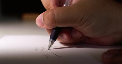 Close Up of Hand Writing With Blue Pen