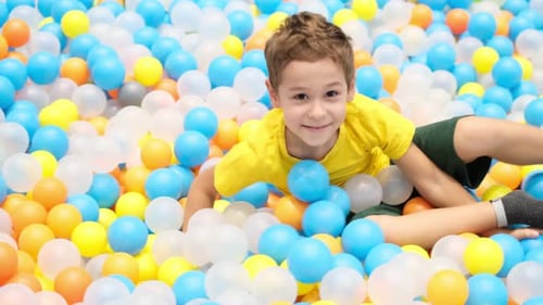 Boy Playing in Playground Colourful Ball Pool Happiness in Bright Colors