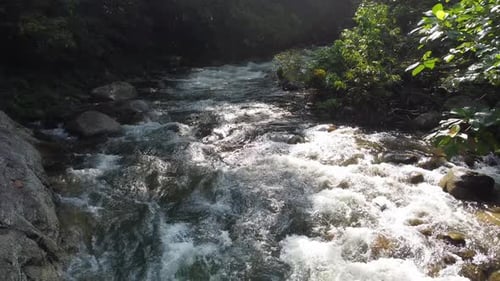 Fly over water flow at rock in light leak