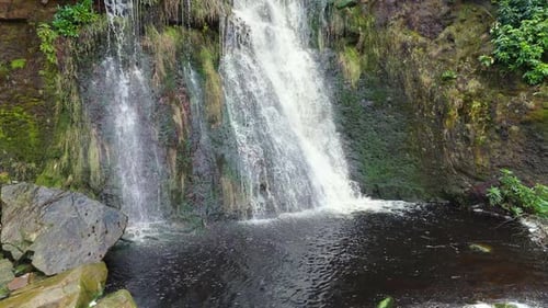 Aerial drone footage of a tall rocky waterfall in the Yorkshire Dales, Pennies. Moorland scene of a