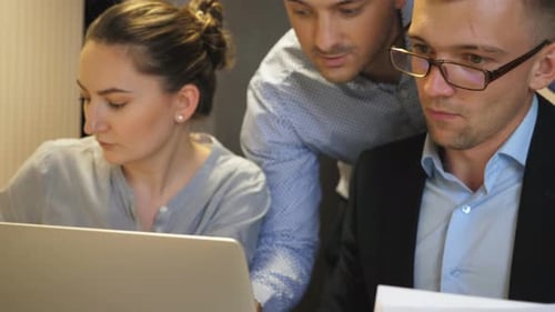 Young Coworkers Examining Statistical Data Information on Laptop at Office
