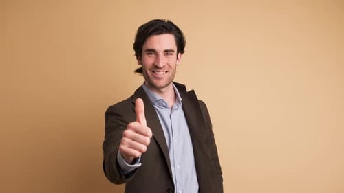 Happy Businessman Showing Thumbs Up in Brown Studio