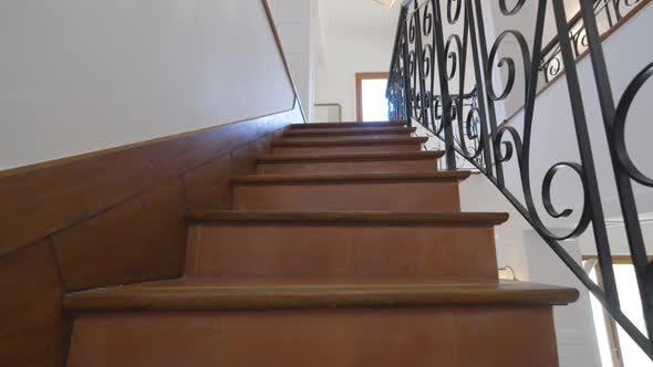 Slow dolly shot up a staircase within a villa with metal decorative ...