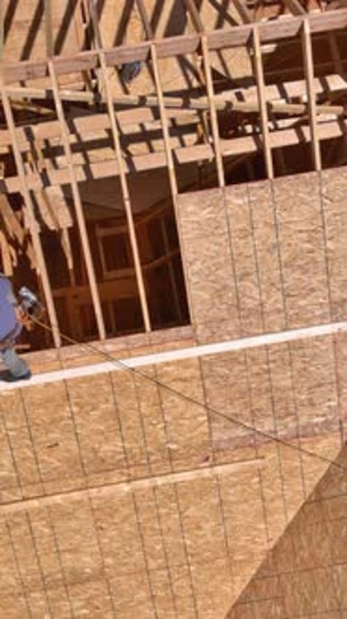 Construction Workers Build Wooden Structure at Residential Site in Daylight Hours