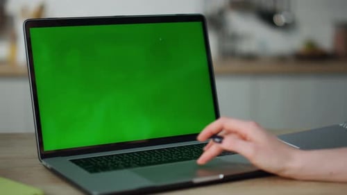 Unknown Woman Working on Greenscreen Laptop Sitting at Kitchen Table Close Up