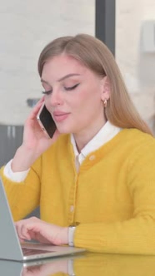 Woman Uses Laptop and Talks on Phone