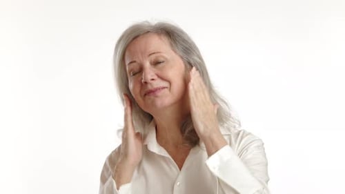 Senior Woman Performing a Facial Massage Routine