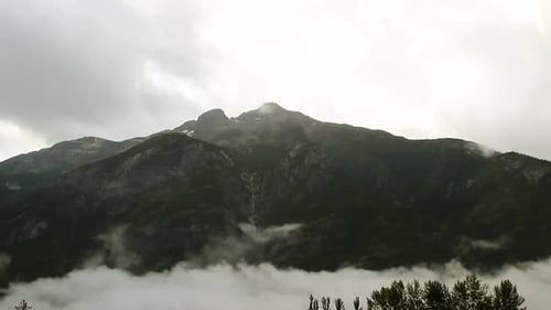 Heavy overcast cloud and ground fog in coastal mountain timelapse
