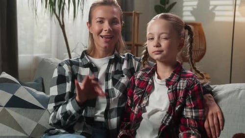 Smiling Woman and Girl Make OK Sign on Couch