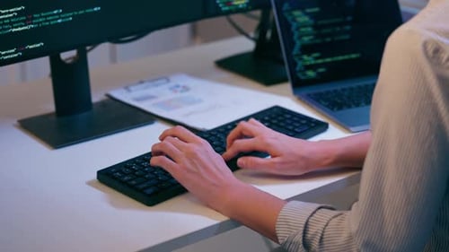 Nahaufnahme einer Softwareingenieurin, die nachts im Büro arbeitet.