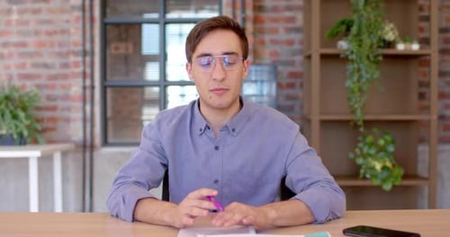 Man Explaining Business Concept at Desk With Plants