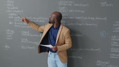 Male Teacher Explaining Code Description on Board