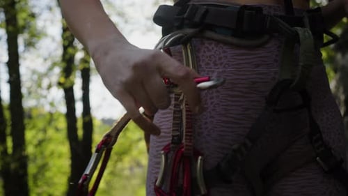 Woman Rock Climber Attaches to the Loop of the Climbing Quickdraw System for Rock Climbing Closeup