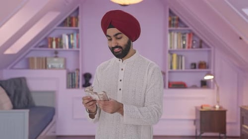 Smiling Man Counting Currency Indoors