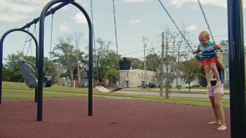 Kinder spielen während des Sommertages in Dartmouth, Nova Scotia, auf Schaukeln