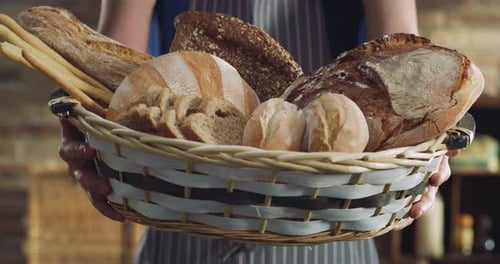Cinematic close up shot of professional artisan baker presenting in camera basket with assortment