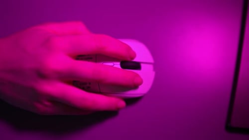 Female Gamer Playing in Games Using Wireless Mouse Sitting at Desk with Computer Desktop Pc in Dark