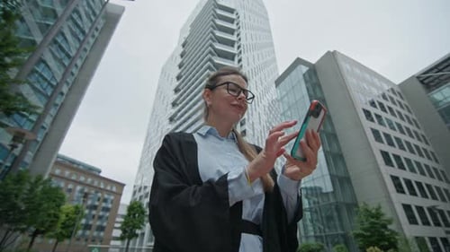 Female Walking Near the Corporate Building Checking Mobile Phone Massage