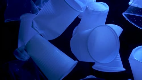 Floating Plastic Cups and Bags in Dark Lighting