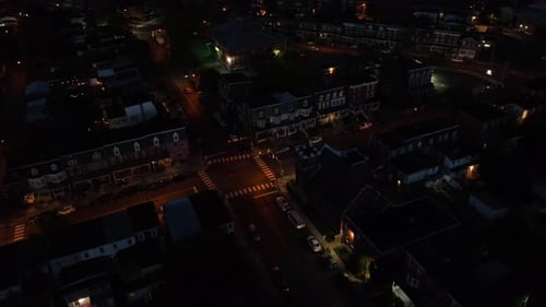 Aerial top down of traffic on junction in quiet small town of USA at night. Lighting lantern in hous