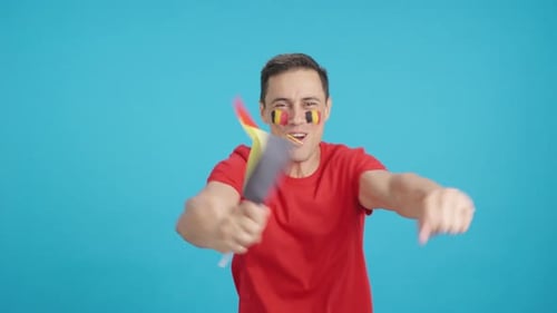 Enthusiastic Man Celebrating with Flag on Blue