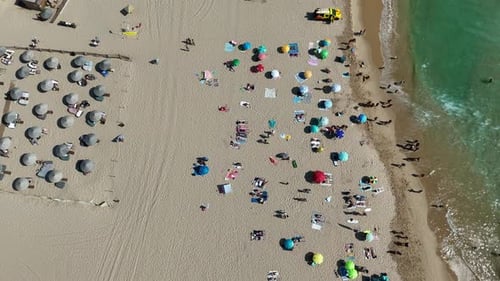 A Beautiful Aerial Beach View Featuring Colorful Umbrellas and Relaxing Sunbathers
