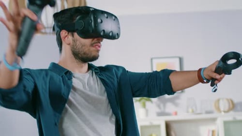 Man Wearing VR Headset Holding Controllers in Living Room