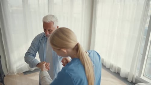 Nurse Helps Old Wheelchair Man to Stand Up Physical Therapist Woman Provides Medical Help Support to