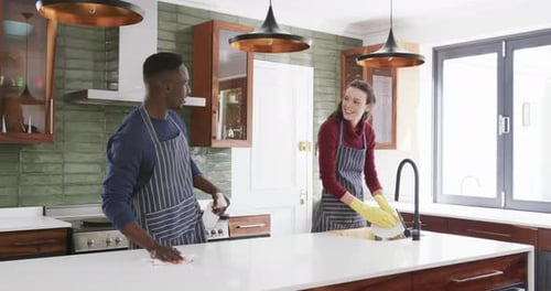 Couple Cleaning Together in a Bright Kitchen