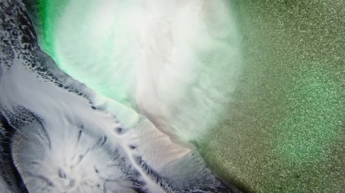 Soft green and white ink diffusion in water with sparkling particles, creating a dreamy atmosphere
