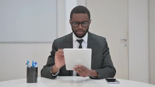 Professional Using Tablet at Desk in Office