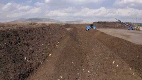 Vista aérea de un sitio de producción de compost industrial. Máquina de torneado de abono