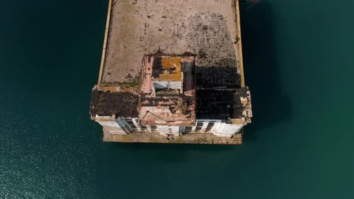 Aerial view of an old rusty pier and blue turquoise water