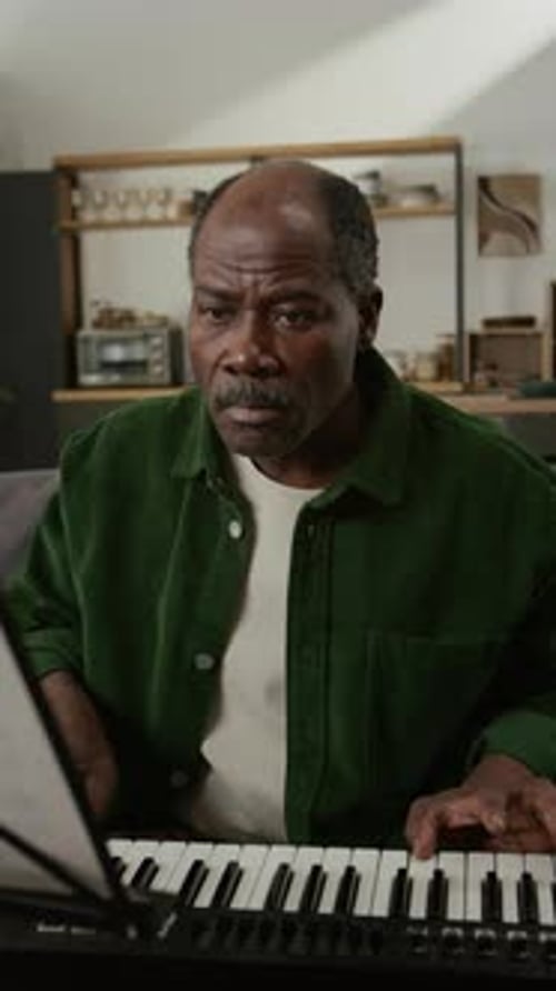 Vertical of Senior African American Man Learning Piano at Home