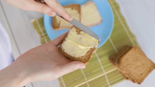 Spreading Butter on Toast for Breakfast